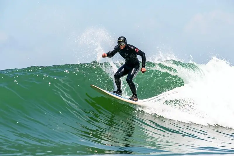 Surfista no momento exato de levantar na prancha durante o take off